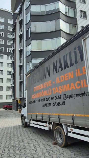 Aydoğan Nakliyat yazılı nakliye kamyonu apartmanların önünde; Samsun evden eve ve asansörlü taşımacılık hizmetini tanıtan gerçek Reels görüntüsü.